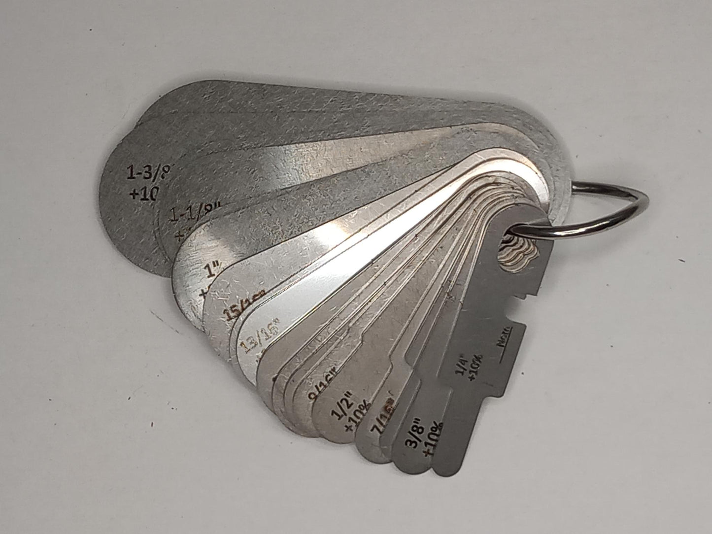 Metal measuring tool set with various scales on a grey background