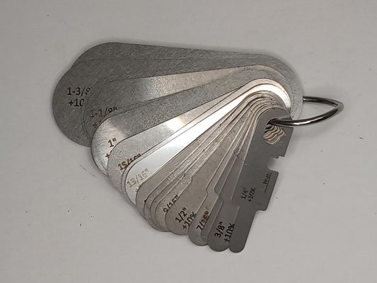 Metal measuring tool set with various scales on a grey background