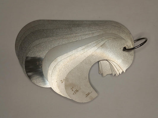 Metal measuring tool set with various scales on a grey background