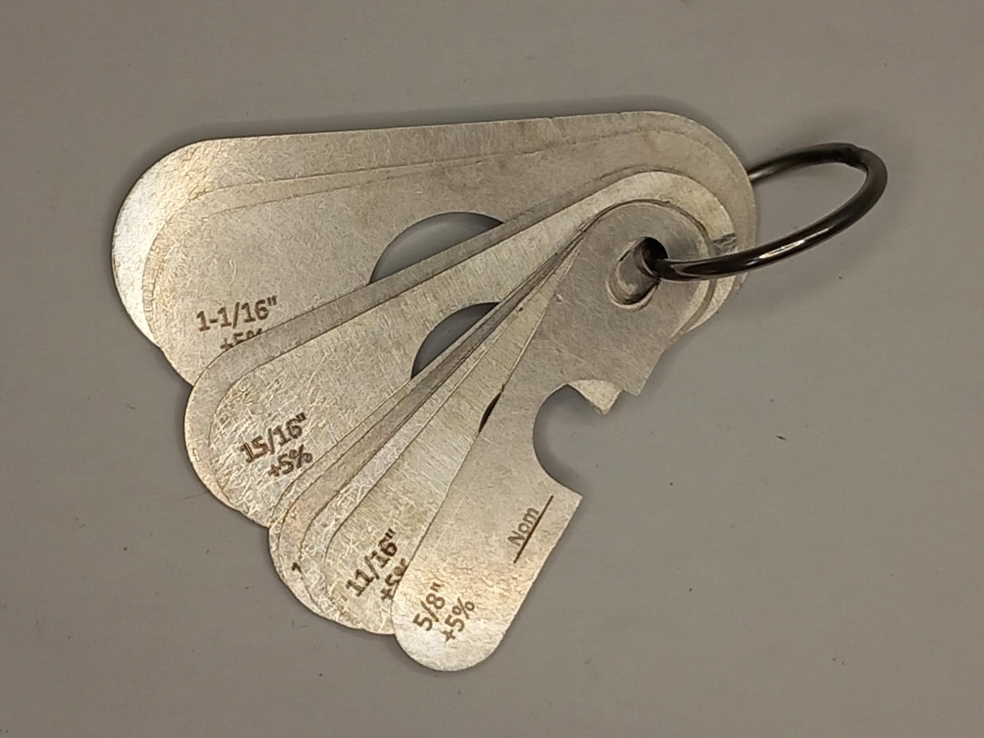 Metal measuring tool set with various scales on a grey background