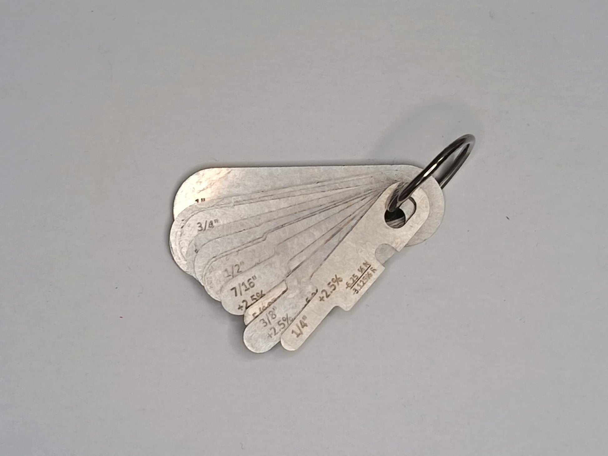 Metal measuring tool set with various scales on a grey background